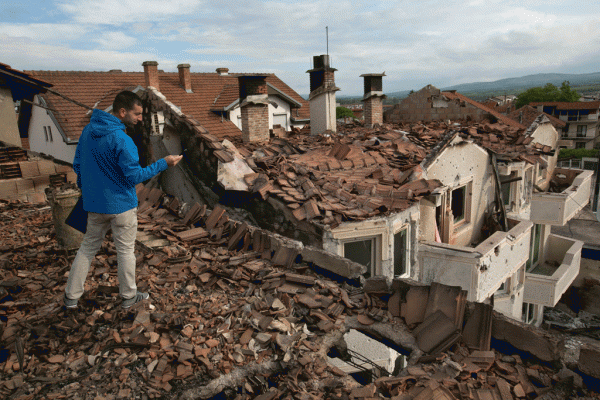 Një banor po fotografon shkatërrimin në lagjen e Trimave ku u zhvilluan luftime përgjatë fundjavës mes policisë dhe një grupi të armatosur në rrethana të paqarta në Kumanovë mëngjesin e 11 majit 2015. (AP Photo/Visar Kryeziu)