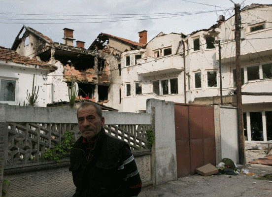 Një banor viziton lagjen ku u zhvilluan luftime në Kumanovë mëngjesin e 11 majit 2015. (AP Photo/Visar Kryeziu)