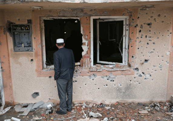 Një banor shikon shtëpinë e dëmtuar në lagjen shqiptare të Kumanovës e cila u dëmtua rëndë nga luftimet në mëngjesin e 11 majit 2015. (AP Photo/Visar Kryeziu)