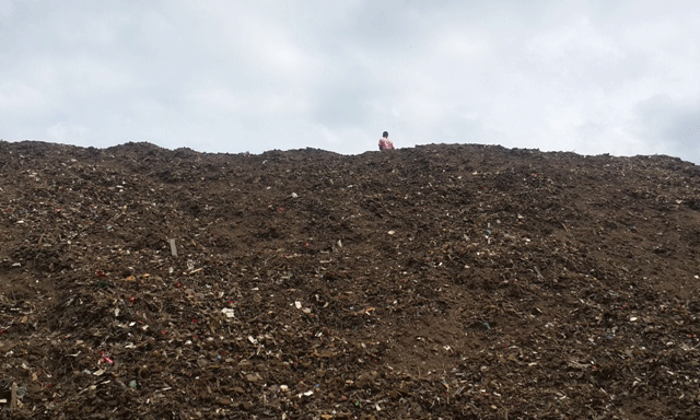 Një punëtor mbi kodrën e krijuar prej mbetjeve te depozituara pranë lumit Shkumbin | Foto nga : Altin Raxhimi