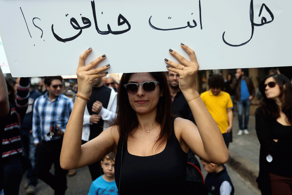 Një aktiviste libaneze mban një pankartë ku shkruhet në arabisht, “A je ti një hipokrit”, ndërsa po merr pjesë në një protestë që kërkon miratimin e një ligji për të lejuar nënshtetasit e Libanit të kryejnë martesa para autoriteteve civile në Bejrut, Liban 1 mars 2015. Martesa civile është e ndaluar në Liban ku njerëzit mund të zgjedhin vetëm martesa fetare në institucionet e religjioneve të ndryshme të vendit. (AP Photo/Hussein Malla)