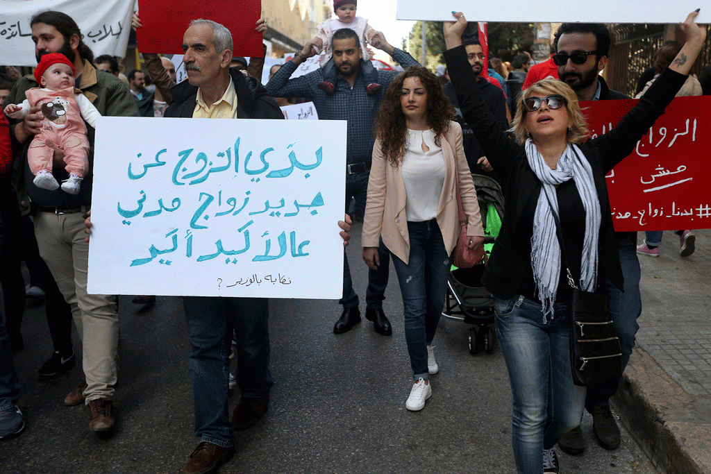 Një aktivist libanez mban pankartën ku shkruhet në arabisht, “Unë dua të martohem sërish – me martesë civile, natyrisht,” ndërsa marshon gjatë një proteste që kërkon të drejtën për martesë civile në Bejrut të Libanit më 1 mars 2015. (AP Photo/Hussein Malla)