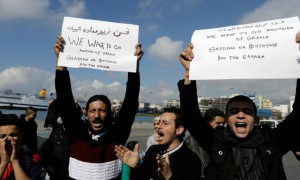 Refugjatët sirianë duke protestuar ndërsa kërkojnë hapjen e kufijve në portin e Pireut në Greqi të premten. | Foto: Beta/AP.