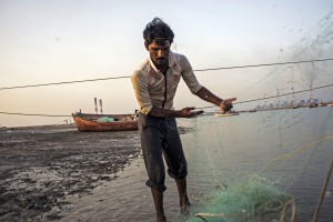 Një peshkatar pranë Mundra, Indi, përgatit rrjetën për ditën tjetër të peshkimit. Vendasit thonë se një projekt i Bankës Botërore në zonë ka varfëruar rezervën e peshkut në zonë. Foto: Sami Siva/ICIJ