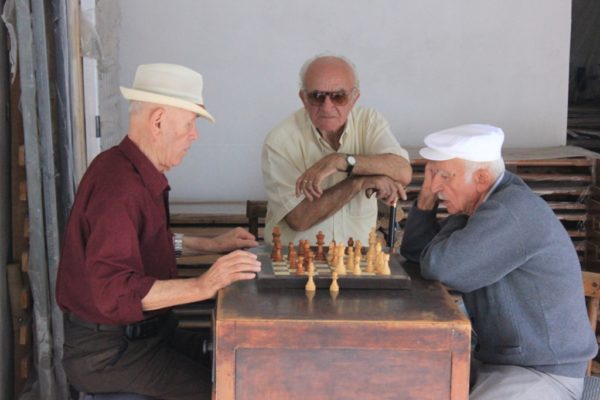 Tre burra të moshuar luajnë shah në një nga hyrjet e braktisura nga hebrejtë në Vlorë | Foto nga : Altin Raxhimi