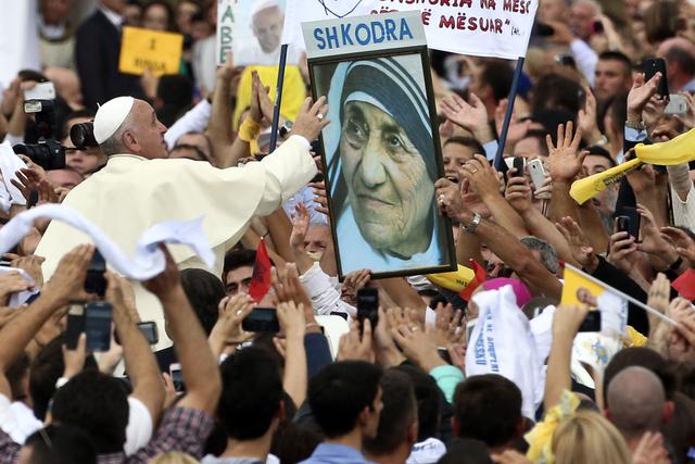 Papa Françesk zgjatet të prek një poster të Nënë Terezës në mes të turmës që ka dalë për ta mikëpritur | Foto nga : Hektor Pusitna/AP