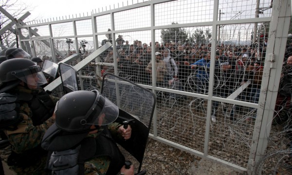 Refugjatë dhe migrantë po përpiqen të shkatërrojnë një portë në gardhin që tashmë ndan Greqinë nga Maqedonia në fshatin Idomeni në Greqi më 29 shkurt 2016. (AP Photo/Petros Giannakouris)