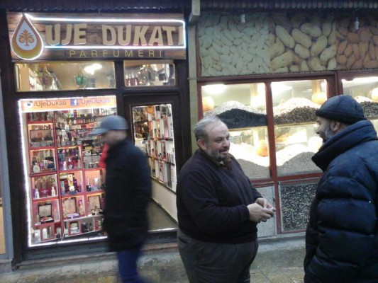 Siriani Bekri Shishman (në mes) para dyqanit të tij në Prizren
