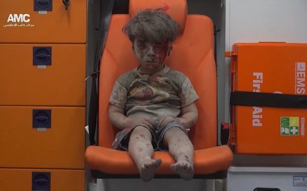 Në këtë çast të ndaluar nga një video e ofruar prej grupit aktivist anti-qeveritar në Siri, Alepo Media Center, një fëmijë rri ulur në një ambulancë pasi është nxjerrë prej një ndërtese të goditur nga një sulm ajror në Alepo, Siri, 17 gusht 2016. Aktivistët e opozitës siriane raportuan një sulm ajror mbi lagjen Qaterji në Alepo të mërkurën në mbrëmje. Foto: Aleppo Media Center/AP