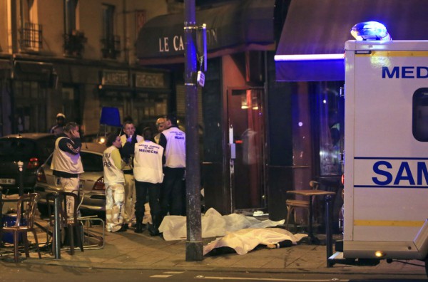 Mjekët po kujdesen për të plagosurit ndërsa disa nga viktimat e një sulmi terrorist në Paris janë vendosur në trotuar jashtë një restoranti. Zyrtarët e policisë raportuan për sulme të shumëfishta terroriste me armë zjarri, shpërthime si dhe me pengmarrje të ndodhura mbrëmjen e sotme. (AP Photo/Thibault Camus)