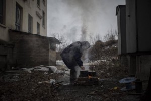 Një burrë gatuan në një zjarr të hapur në qytetin Debaltseve në Ukrainë | AP Photo/Evgeniy Maloletka