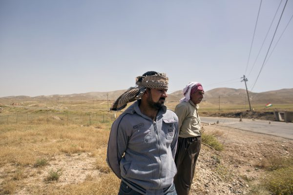 Në këtë foto të 19 majit 2016, Arkan Qassim, në qendër qëndron në zonën ku dëshmoi vrasjen e dhjetërave burrave yazidi. (AP Photo/Maya Alleruzzo)